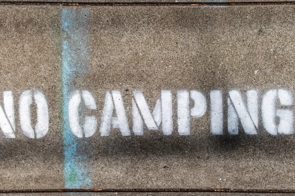 "No Camping" stencil on concrete.